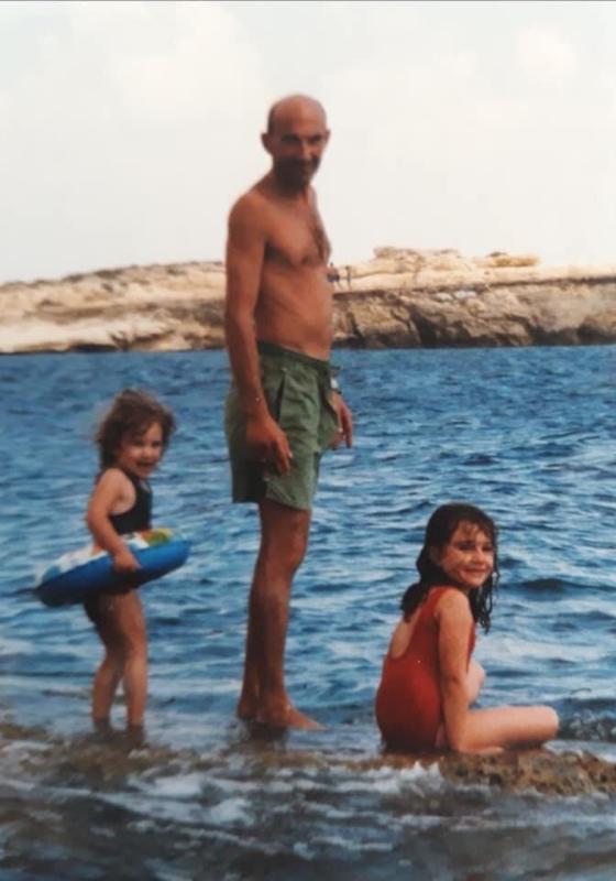 Two girls with their dad next to the water