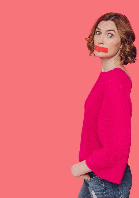 Picture of a person in a pink jumper with red tape across their face.