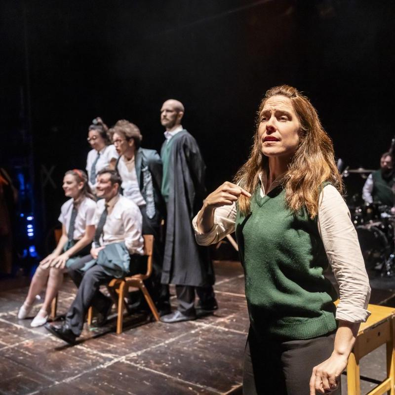 In the foreground a BSL Interpreter. In the background five performers posing for a school photo
