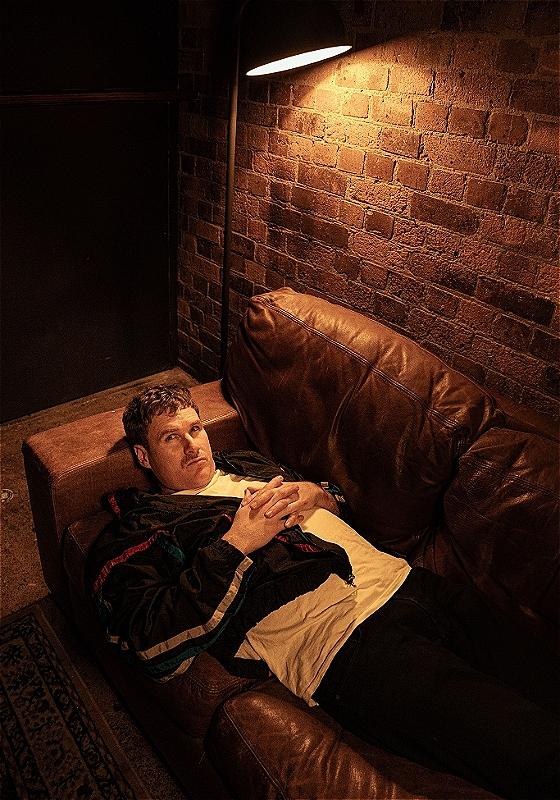 A man relaxing on a couch, enjoying a moment of rest and comfort.