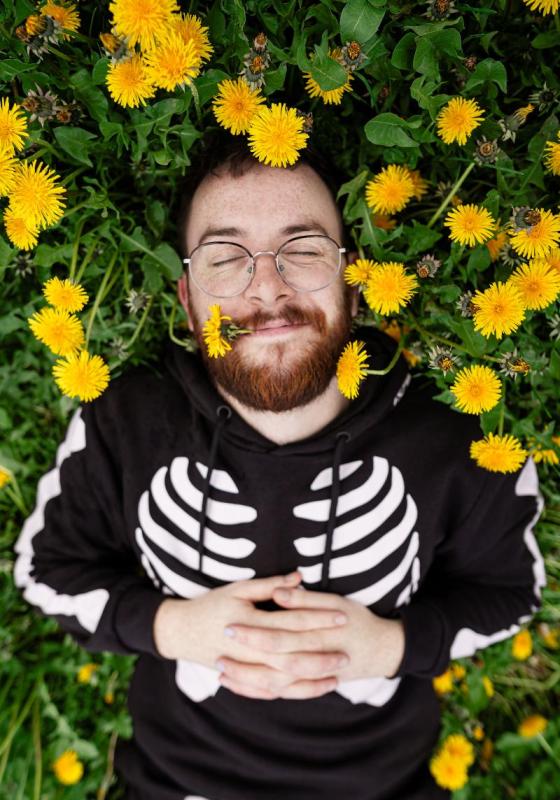 Rich lying in a field of dandelions