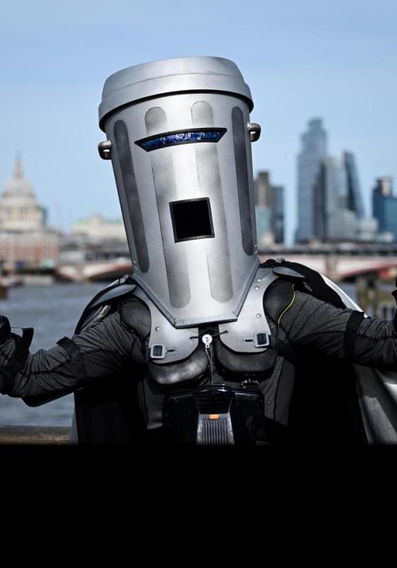 A man in a costume wearing a dustbin helmet, ready for an event or performance.