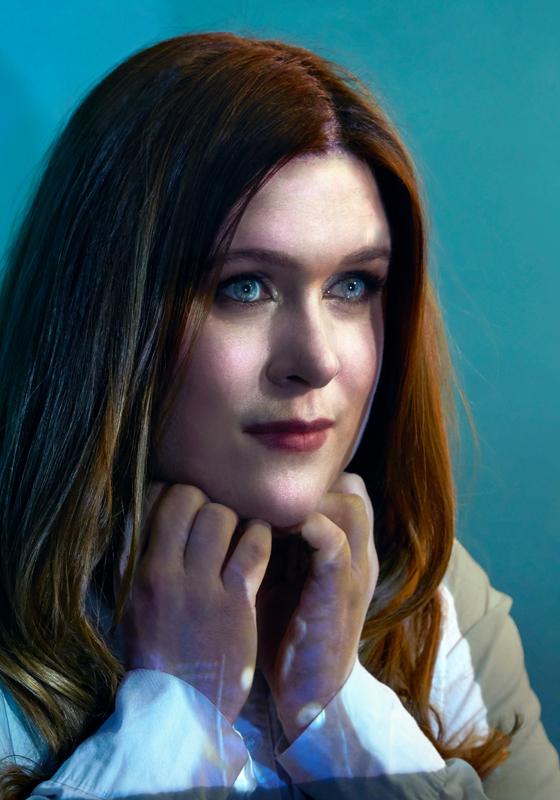 Person in a white shirt against a blue background.