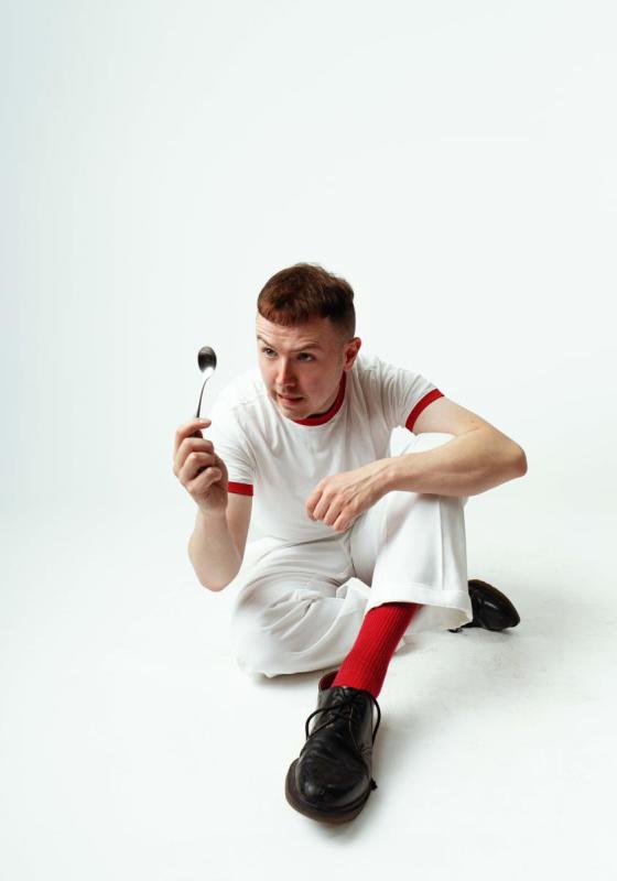 A person sitting on the floor holding a spoon