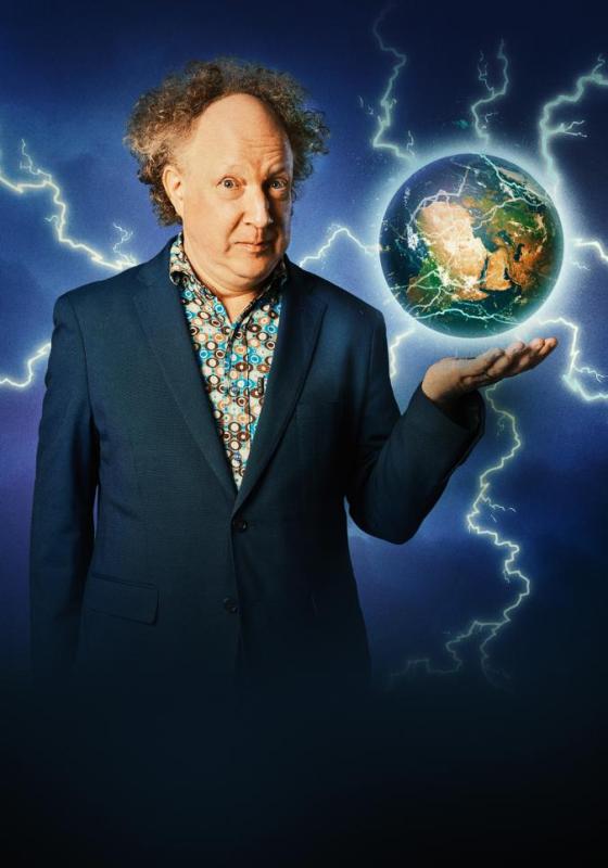 A man in a suit holds an image of Earth in his hand, surrounded by lightning effects. He has curly hair and wears a patterned shirt under his blazer. The background is dark and dramatic.