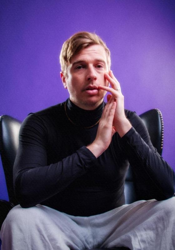 A person sitting in a chair with his hands on his face