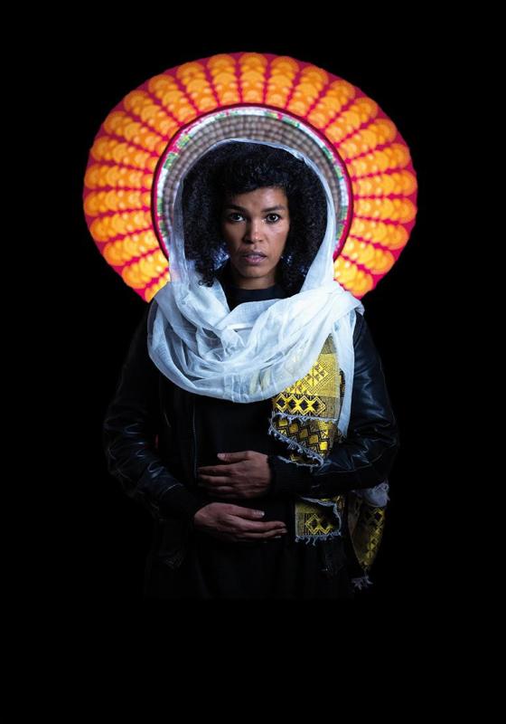 Person in traditional attire with a colourful, round backdrop.