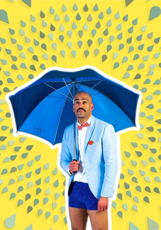 A person in a suit and shorts holding a blue umbrella