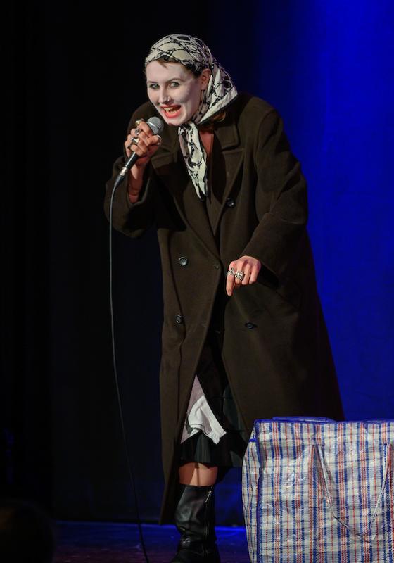 Image of Ozzy Algar, performer, onstage with a bag