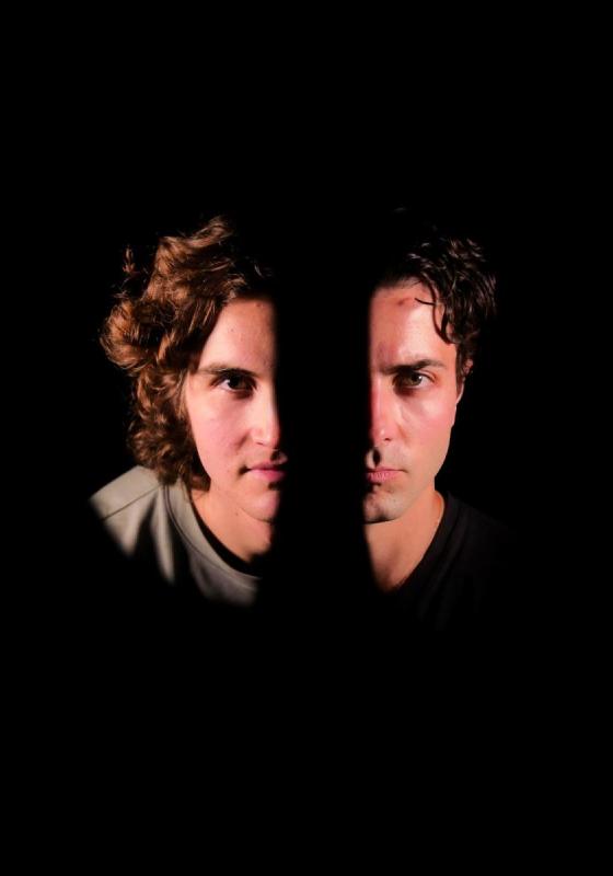 Half the faces of two men. The rest of the photo is obscured in darkness.