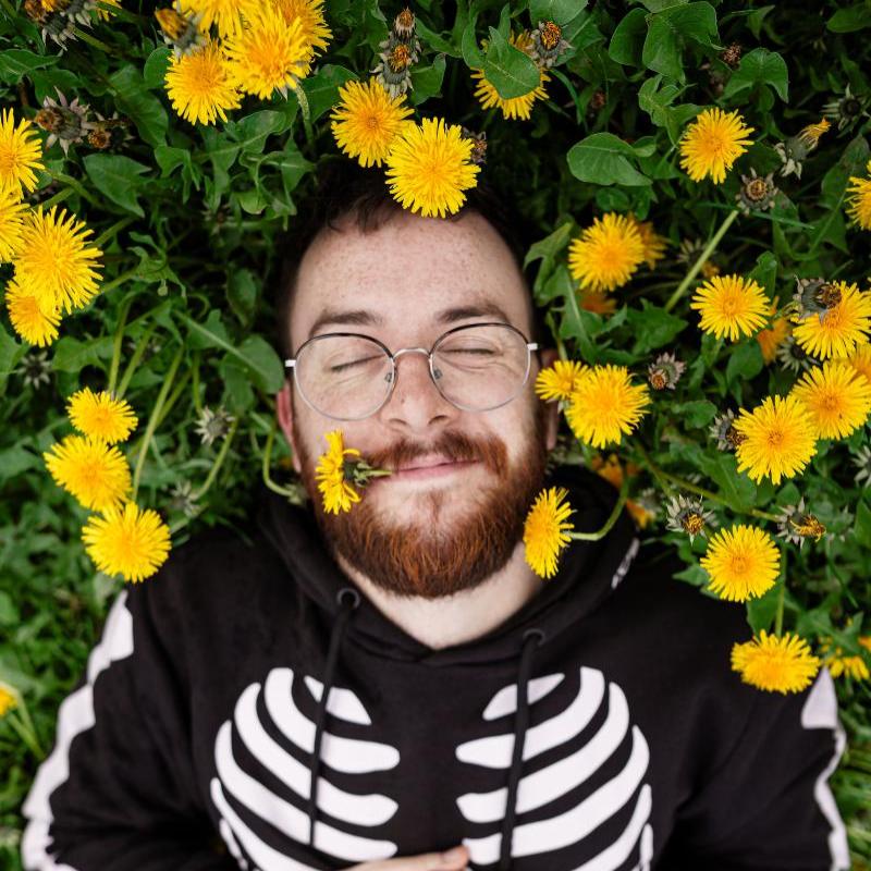 Rich lying in a field of dandelions