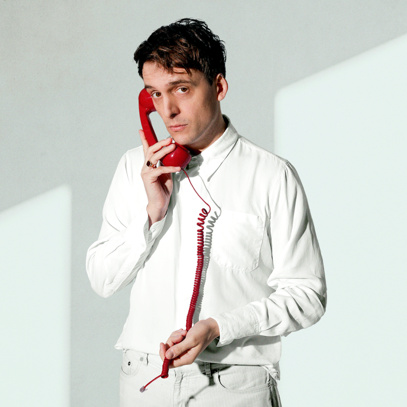 Graham holding a disconnected red telephone