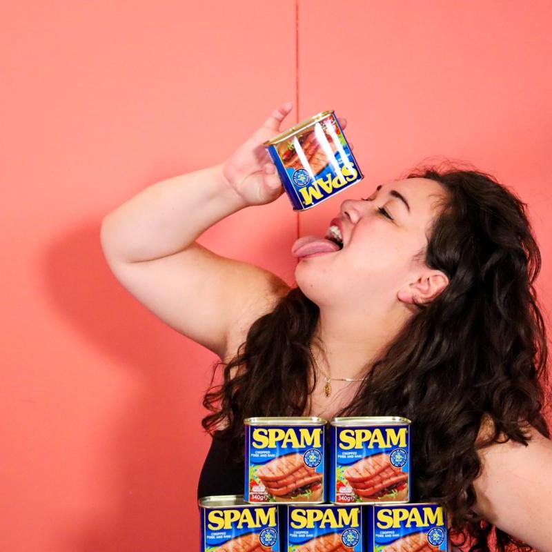 Sierra has her tongue sticking out while emptying a can of Spam