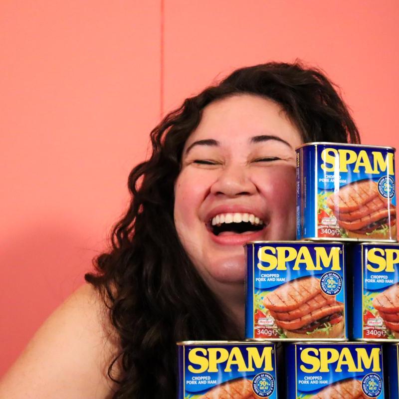 Sierra is smiling behind a pile of Spam cans