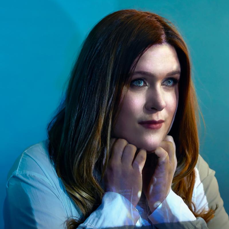 Person in a white shirt against a blue background.