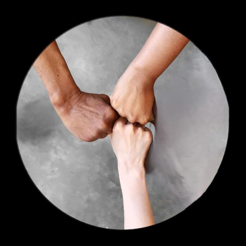 Three hands of different skin tones doing a fist bump, captured within a circular frame against a neutral background.