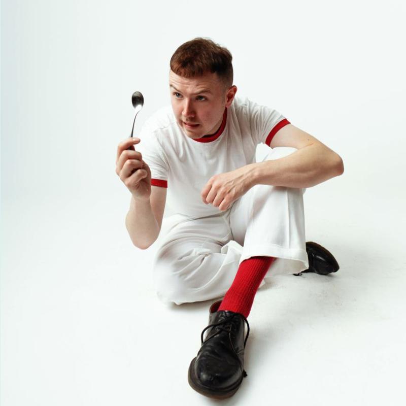 A person sitting on the floor holding a spoon