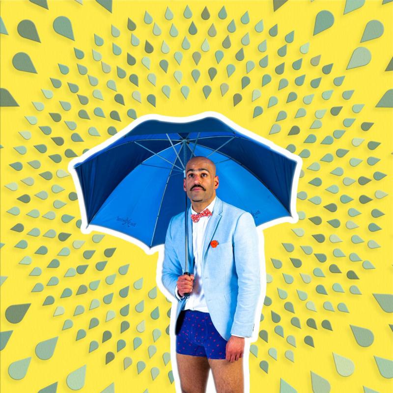 A person in a suit and shorts holding a blue umbrella