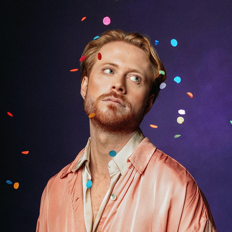 John Tothill gazing off camera as confetti falls around him