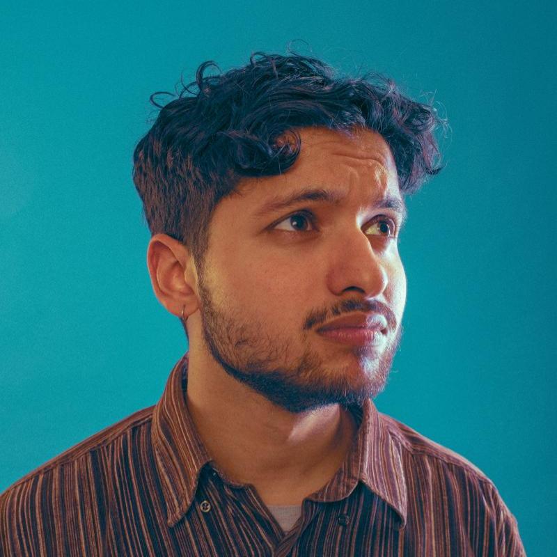 Image of Rohan Sharma, performer, in front of a blue background