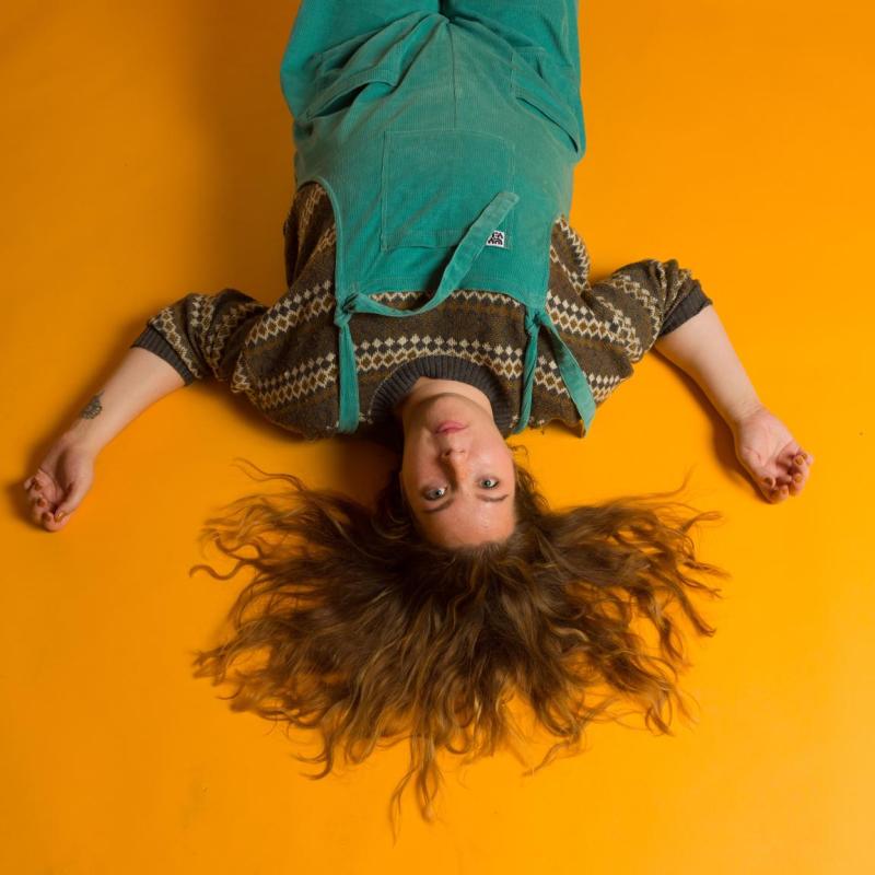 Jessie laying upside down on an orange floor