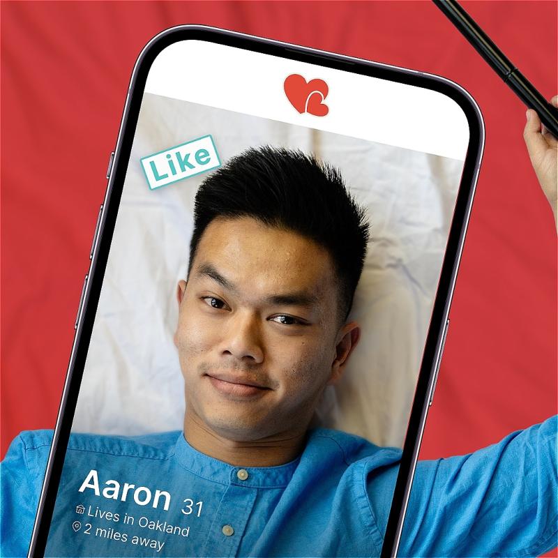 Aaron is on a dating app, the profile reads Aaron, 31 with a like message on it. holding a cane in their right hand. 